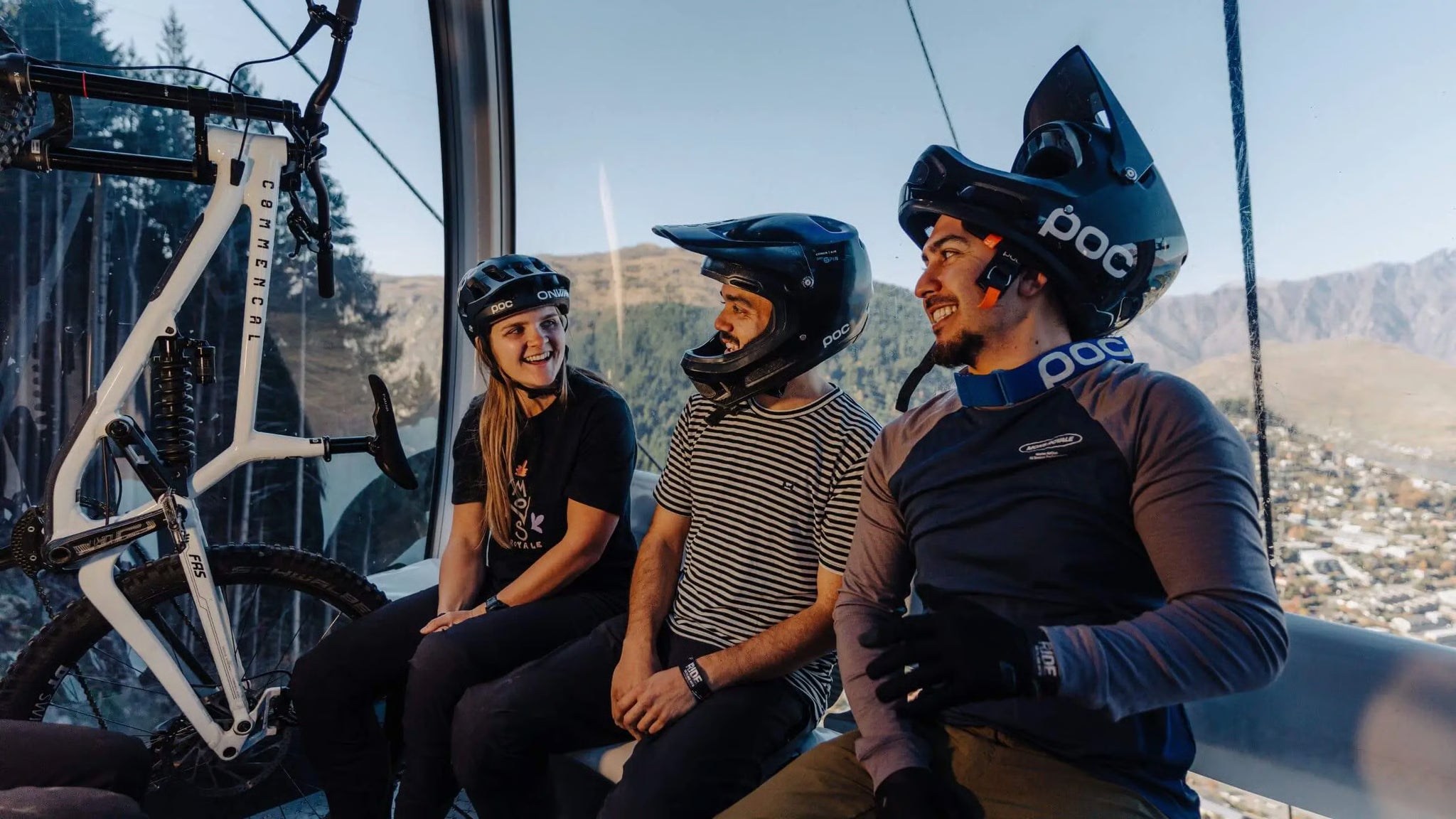 Riders laughing inside the Skyline gondola with a downhill bike racked beside them